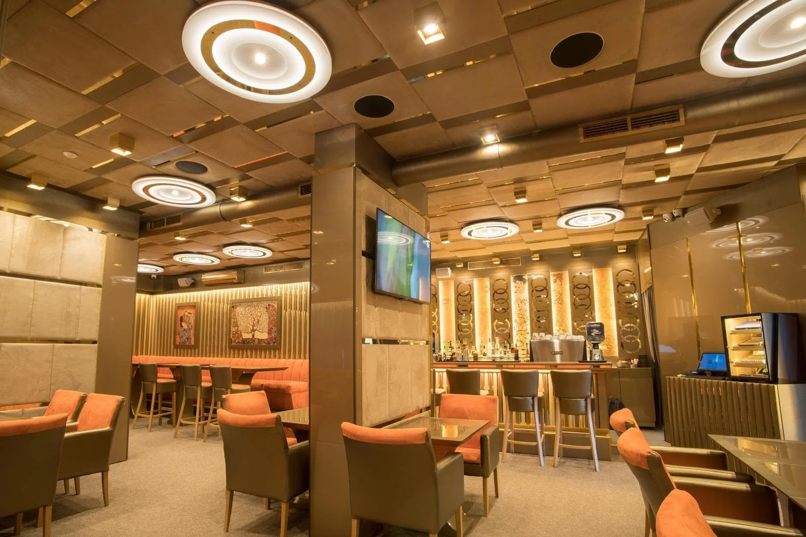 Бар зоната на BLEND Bar & Dinner с високи столове и телевизор